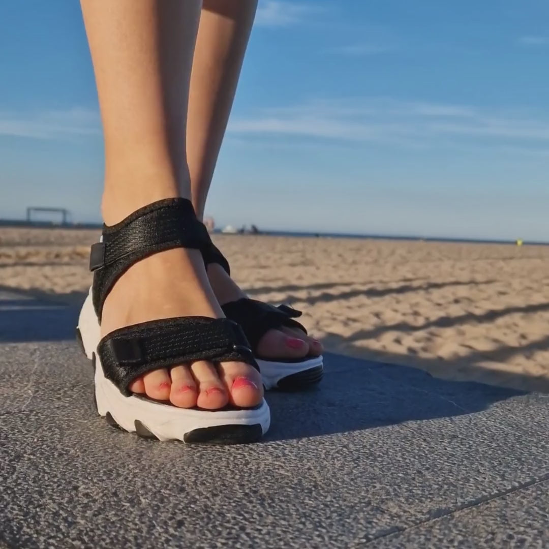 Cargar video: mujer camina por el paseo con sandalias cómodas